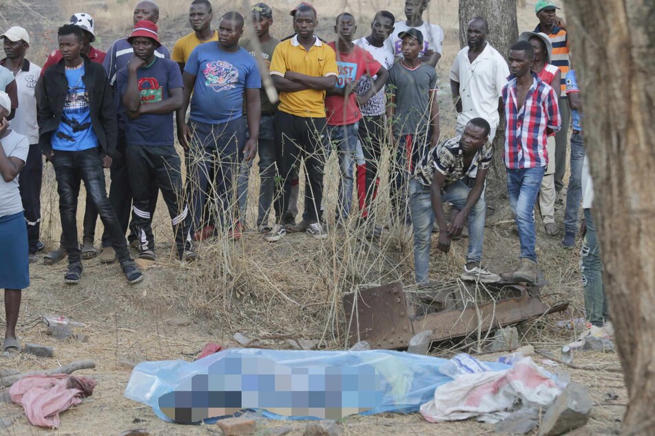 Die Leiche eines Bergarbeiters liegt in Plastikfolie gehüllt auf dem Boden, nachdem sie aus dem eingestürzten Schacht einer Goldmine in Chegutu geborgen worden ist.