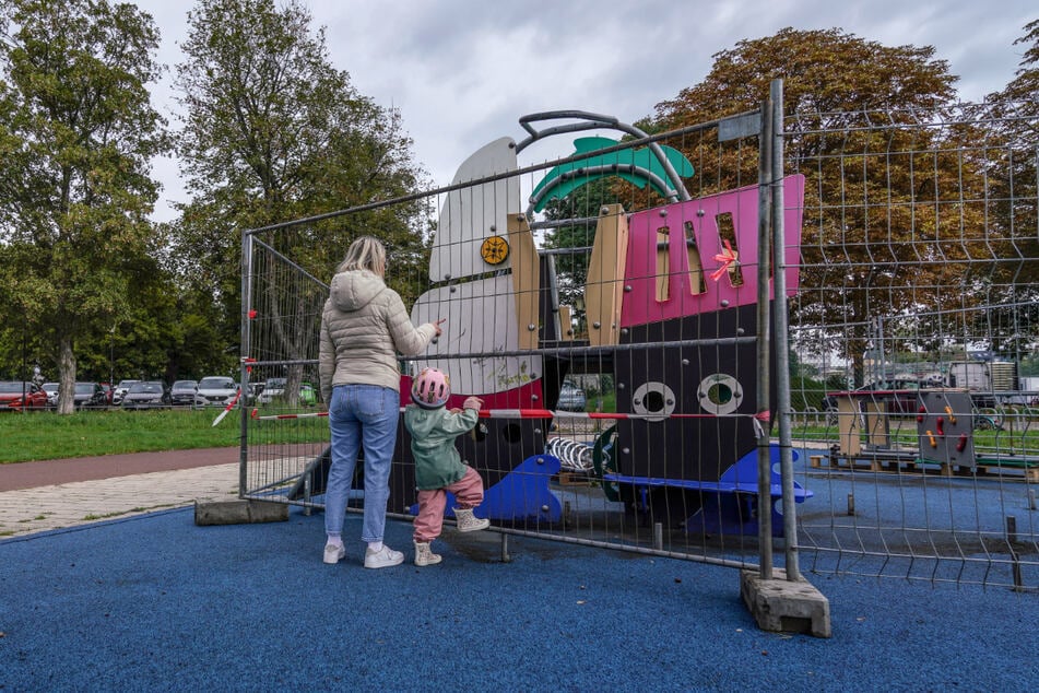 Jennifer Graf (33) und Tochter Mathilda (3) stehen vor dem abgesperrten Kinderspielplatz im Sportpark Ostra. Nach dem Elbehochwasser müssen einzelne Anlagen wieder instand gesetzt werden.