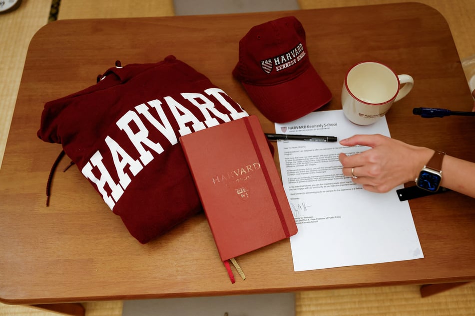 Yu-Hsuan Lin lays out a Harvard hat, mug, hoodie, and her admission letter to the university on a table in Taipei, Taiwan.