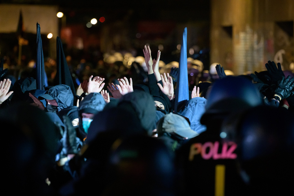 Teilnehmer der Demonstration unter dem Motto "Verboten gut - Anarchismus in die Offensive - Anarchistischer 1. Mai" halten nach einem Schlagstock-Einsatz der Polizei am S-Bahnhof Veddel ihre Hände in die Höhe. (Archivbild)