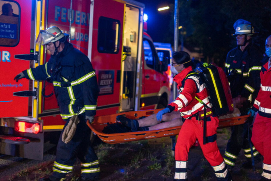 Rettungskräfte bringen die schwer verletzte Frau in ein Krankenhaus.