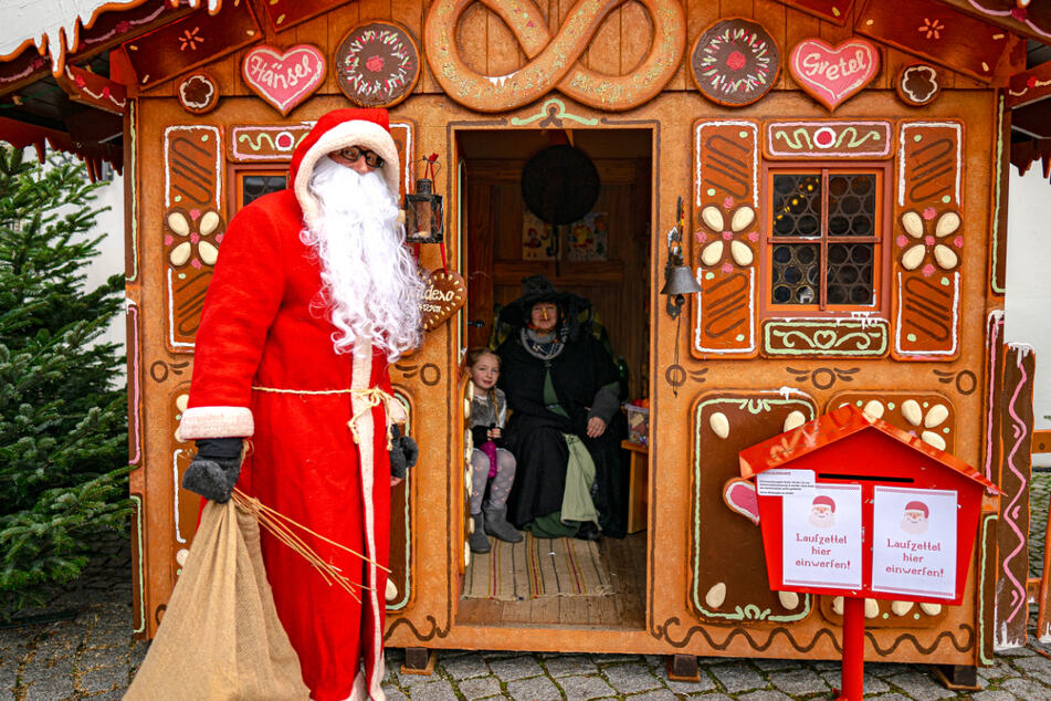 Weihnachtsmann und Hexe warten auf Besucher im Hexenhaus.