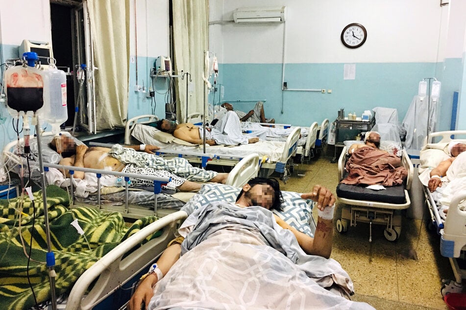 Männer, die bei dem tödlichen Anschlag in der Nähe des Flughafens von Kabul verletzt wurden, liegen in einem Krankenhaus.