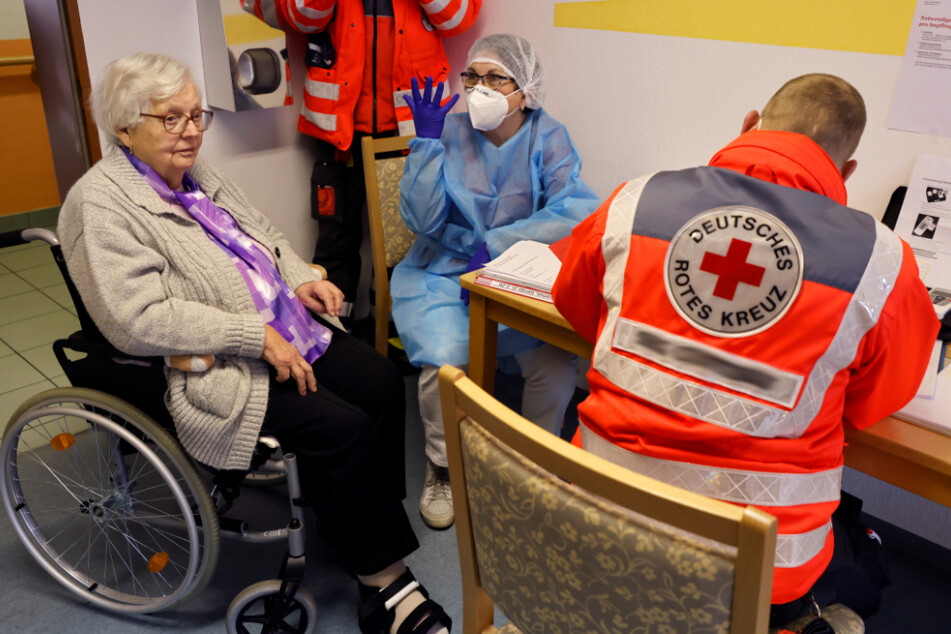 Das Deutsche Rote Kreuz (DRK) spricht mit einer Seniorin, bevor sie ihre Corona-Impfung bekommt. Im Landkreis Sonneberg wird das DRK nun älteren und pflegebedürftigen Menschen helfen, einen Impftermin zu organisieren.
