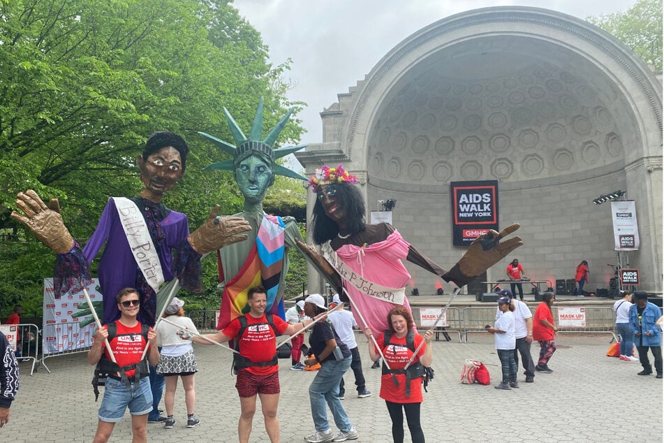 Volunteers controlling giant puppets of (from l. to r.) Billy Porter, the Statue of Liberty, and Marsha P. Johnson started a dance party at the finish line of AIDS Walk New York 2022 at the Naumberg Bandshell in Central Park.