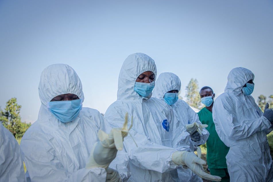 Volunteers put on their personal protective equipment before recovering the body of a child, presumed to have died of Ebola virus disease, in Bunia, Democratic Republic of Congo, on June 11, 2026.