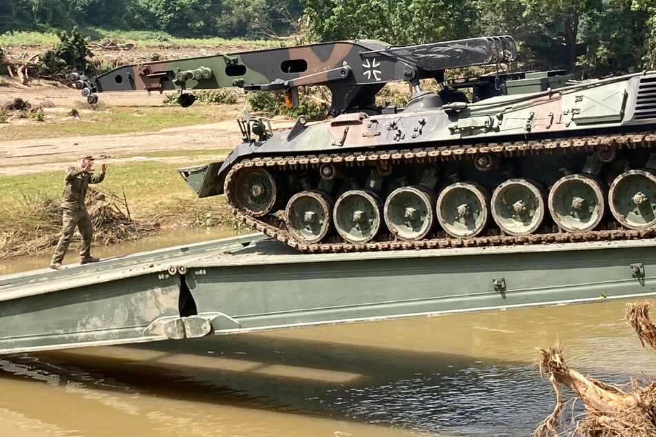 Einsatzkräfte der Bundeswehr bauen eine Behelfsbrücke über die Ahr im Weinort Rech im Landkreis Ahrweiler.