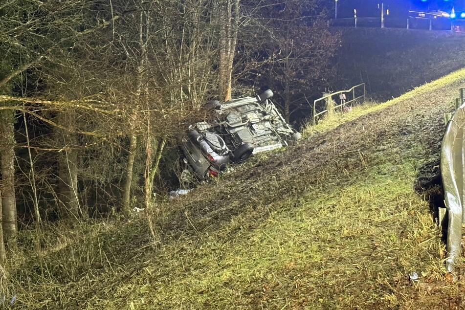 Das Auto blieb auf dem Dach an einem Abhang liegen.