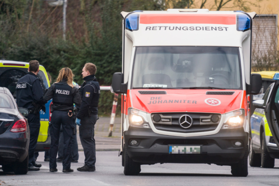 Ein Rettungswagen und Polizisten stehen in einer Straße. (Symbolbild)