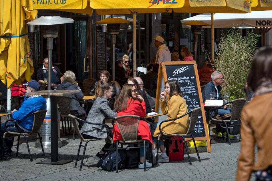 Gäste genießen Speis und Trank bei schönem Wetter in der Leipziger Innenstadt. Sachsen wurde nun von Booking.com als gastfreundlichstes Bundesland ausgezeichnet. (Archivbild)