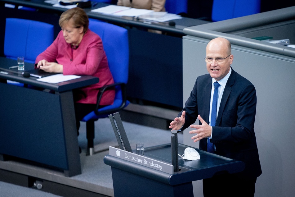 Ralph Brinkhaus (CDU), Vorsitzender der CDU/CSU-Bundestagsfraktion, spricht vor Bundeskanzlerin Angela Merkel (CDU).