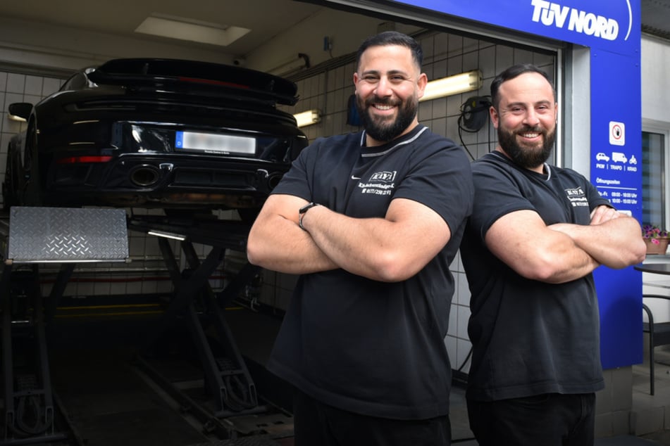 Serkan (l.) und Engin Kaya stehen vor ihrer TÜV-Werkstatt.