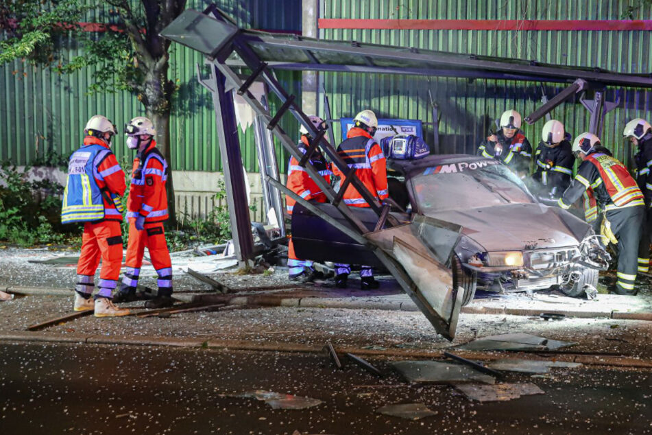 BMW rast in Bushaltestelle und fängt Feuer: Fahrer muss schwer verletzt gerettet werden!