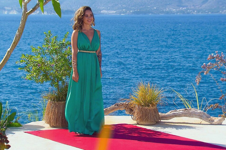 Wie eine griechische Liebesgöttin Aphrodite steht Melissa Damilia (25) kerzengerade an der sonnigen Küste Kretas und hofft, dass auch normale Männer dem Auto entsteigen.