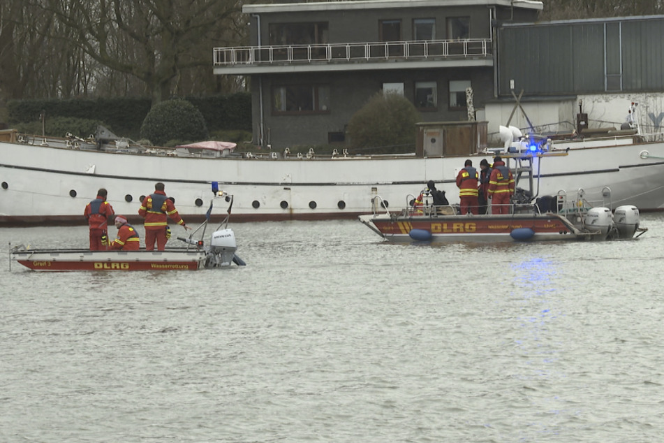 Rettungskräfte der Wasserrettung DLRG und Polizeitaucher suchen in der Elbe neben dem Binnenschiff "Lusitania" nach einem Matrosen.