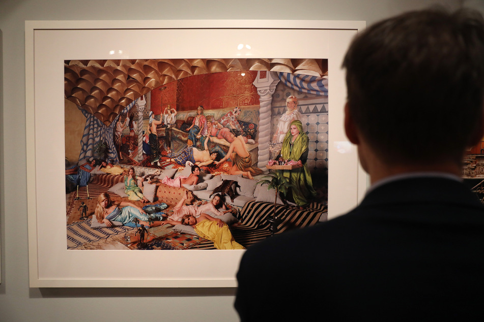 Ein Mann betrachtet eine Fotografie von Daniela Rossel aus der Serie "Ricas y Famoses" (Reis he und Berühmte).