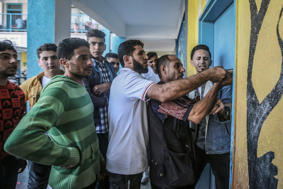 Palästinenser versuchen eine Tür der UN-Schule zu öffnen, in der sie Schutz suchen. Sie mussten während der israelischen Luftangriffe aus ihren Häusern fliehen inmitten des eskalierenden Aufflammens der israelisch-palästinensischen Gewalt.