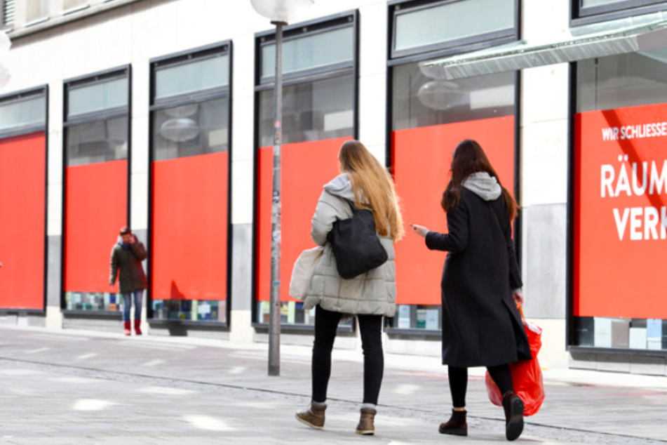 Zwei Frauen gehen in der Münchner Innenstadt an Schaufenstern vorbei.