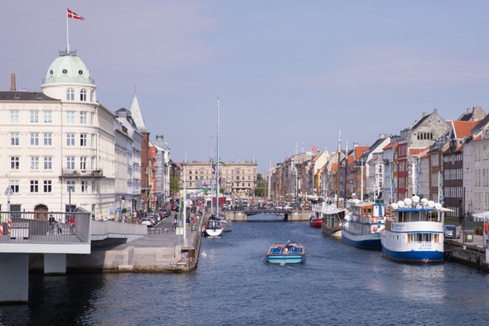 Dänemark, Kopenhagen: Ein kleines Ausflugsboot fährt in der Innenstadt in den Nyhavn.