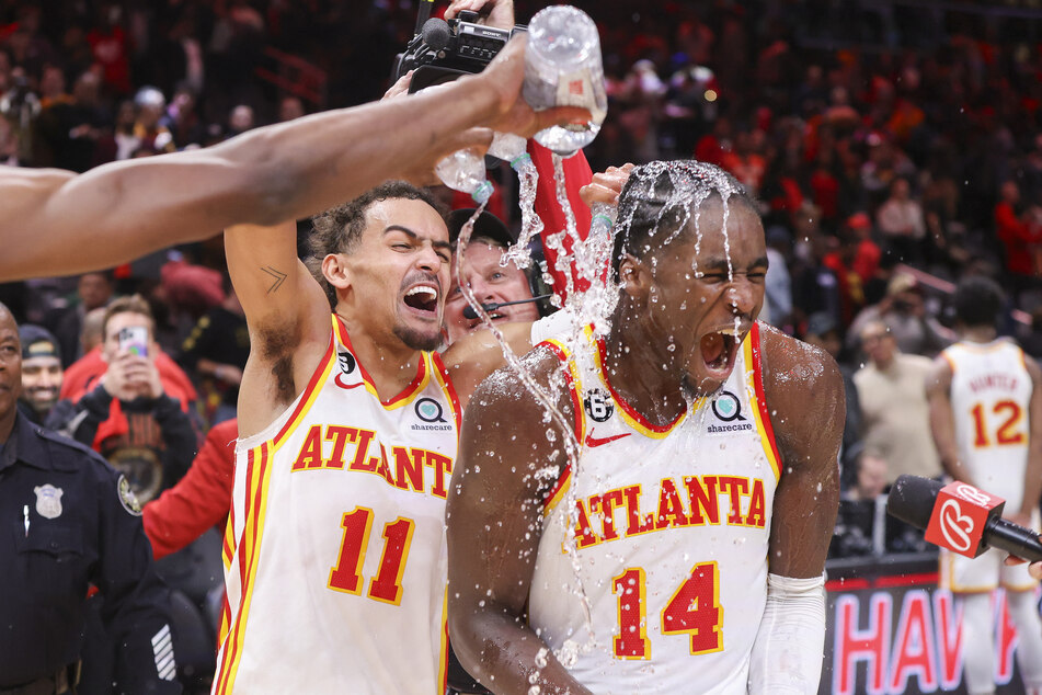 Trae Young (l.) and A.J. Griffin celebrate the Hawks' dramatic overtime win over the Raptors.