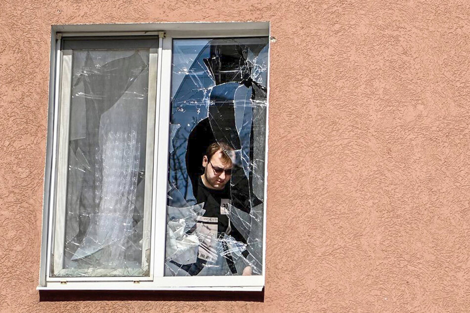 Ein Mann betrachtet das zerbrochene Fenster seines Hauses nach dem Beschuss durch die Ukraine.