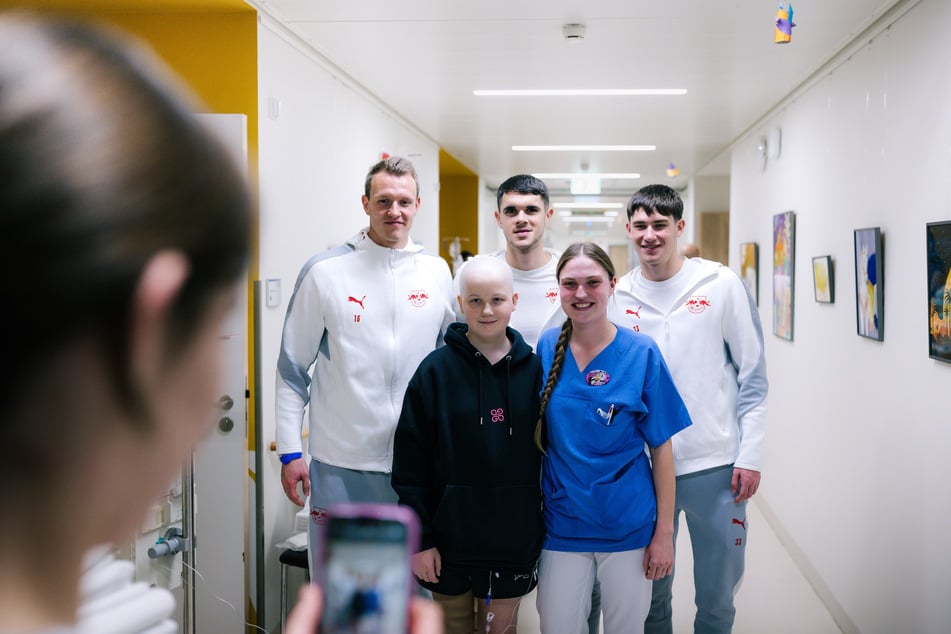 Lukas Klostermann (29, l.), Kosta Nedeljkovic (19, M.) und Andrija Maksimovic (18, r.) posieren mit einer Pflegerin und einer Patientin für ein Erinnerungsfoto.