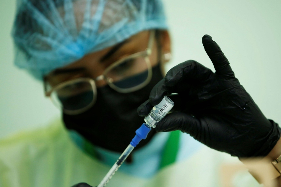 A medical professional prepares the dosage for a Covid-19 shot.