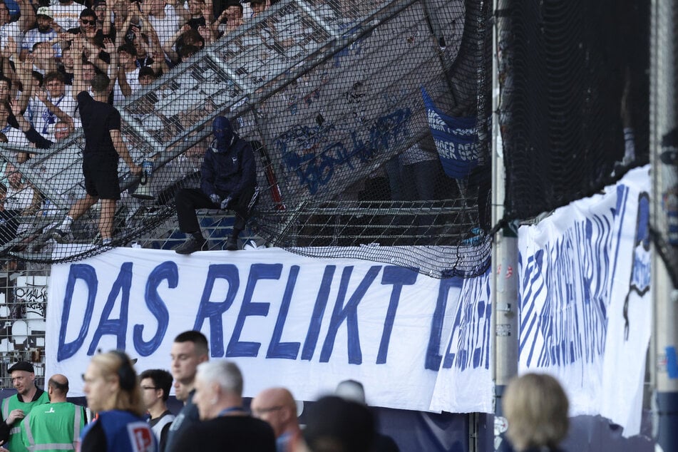 Hertha-Fans zeigen ihr großes Spruchband "Das Relikt des Arbeiterclubs: Wir malochen, ihr kassiert".