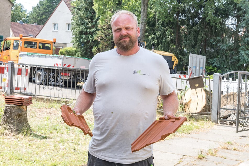 Stefan Dietze (42) mit kaputten Dachziegeln.