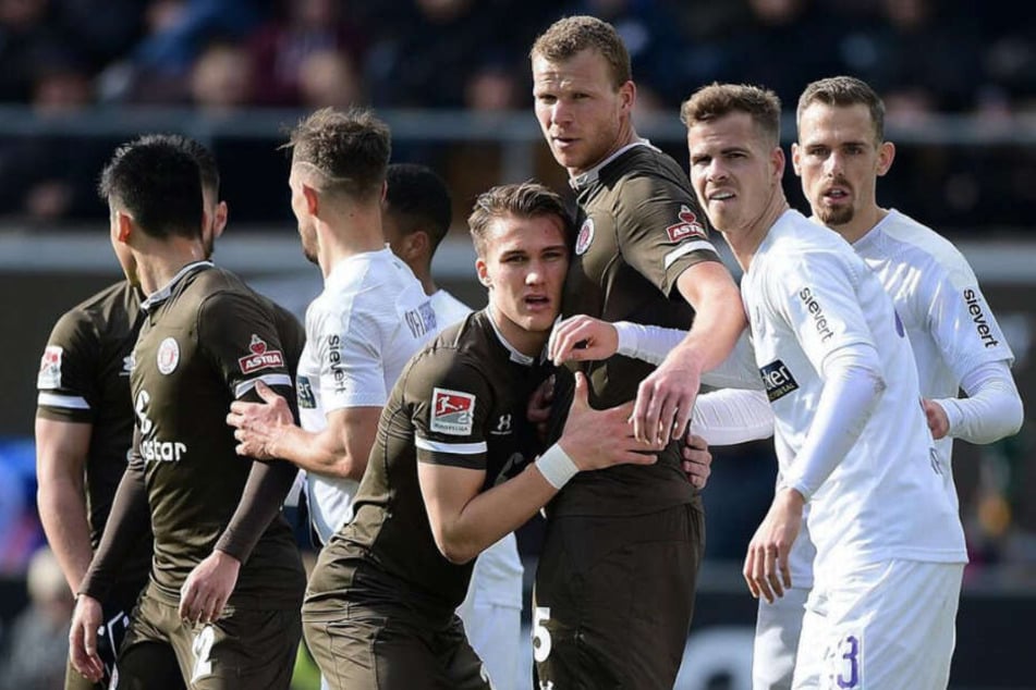 St. Paulis Abwehrspieler Leo Östigard lehnt sich bei einem Eckball an die Brust von Mitspieler Henk Veerman an.