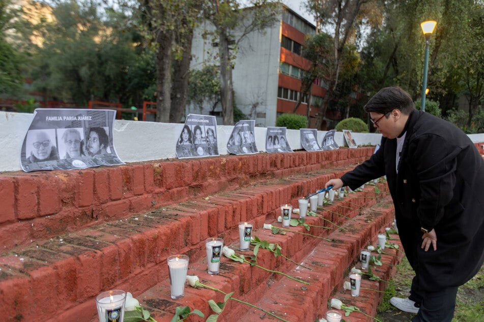 A woman lights a candle during a ceremony in remembrance of the victims of the devastating 1985 earthquake in Mexico City.