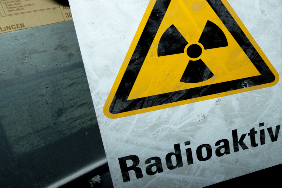 An einer Kette hängt ein Warnschild mit der Aufschrift "Radioaktiv". (Symbolbild)