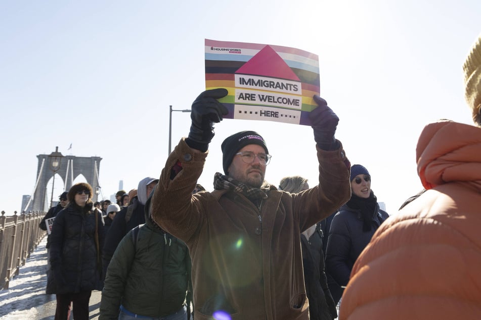 A protester holds a sign reading "Immigrants Are Welcome Here" during a march across the Brooklyn Bridge in New York City.