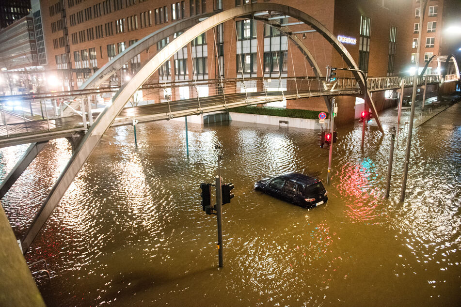 Die Speicherstadt ist überschwemmt, ein Auto treibt in den Fluten.