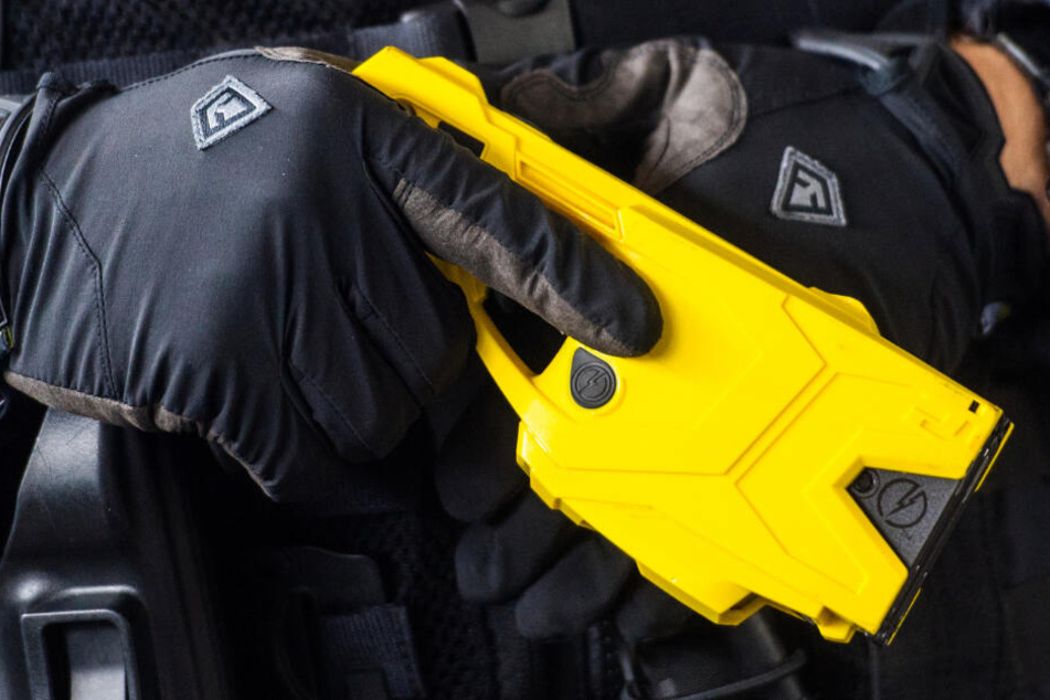 Ein Polizist hält einen Taser. (Symbolbild)