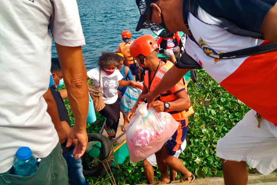 Familien werden von Mitgliedern der philippinischen Küstenwache auf sichereren Boden in der Provinz Camarines Sur im Osten der Philippinen gebracht, während sie sich auf die Ankunft von Taifun Goni vorbereiten.
