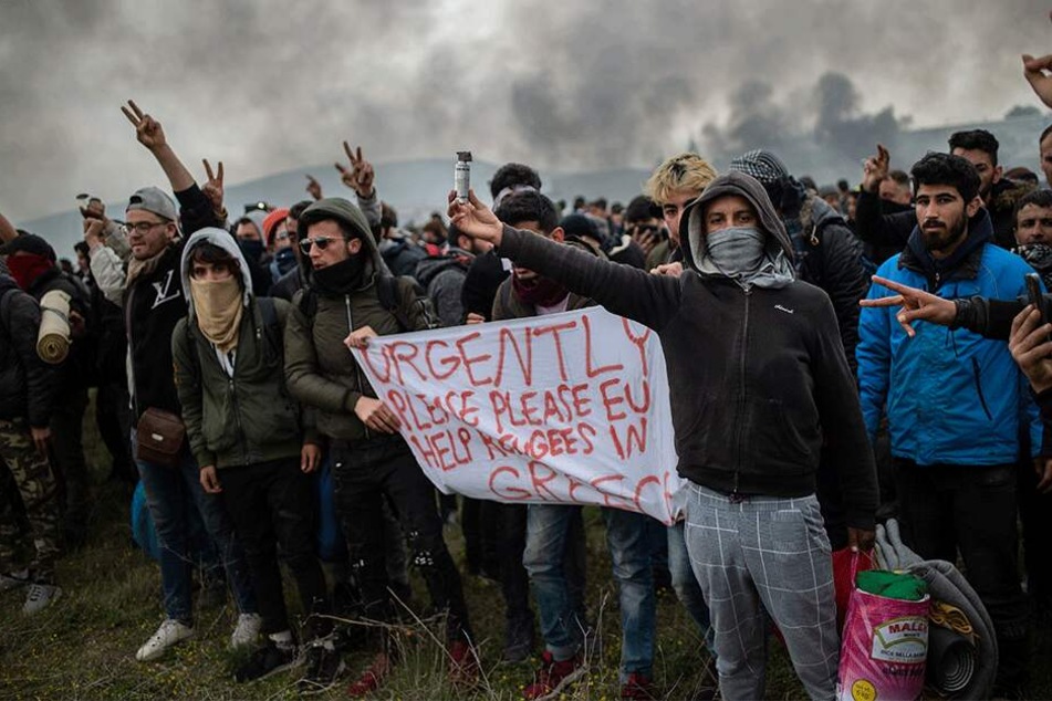 Protestierende Migranten halten ein Banner mit der Aufschrift "Schnell, Bitte, Bitte EU, helft den Migranten in Griechenland".