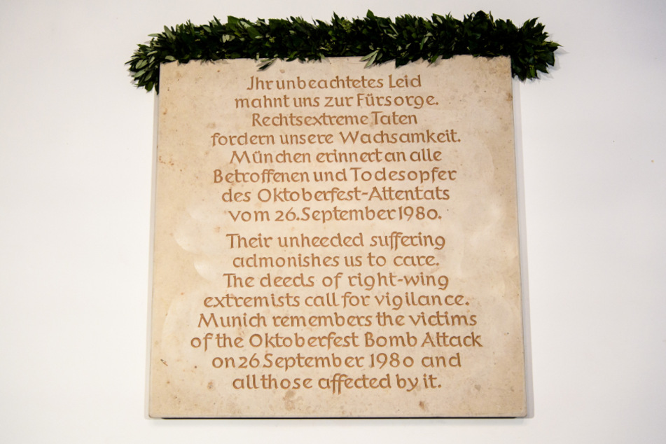 Eine Gedenktafel an das Münchner Wiesn-Attentat ist an einem Treppenaufgang im Rathaus zu sehen.