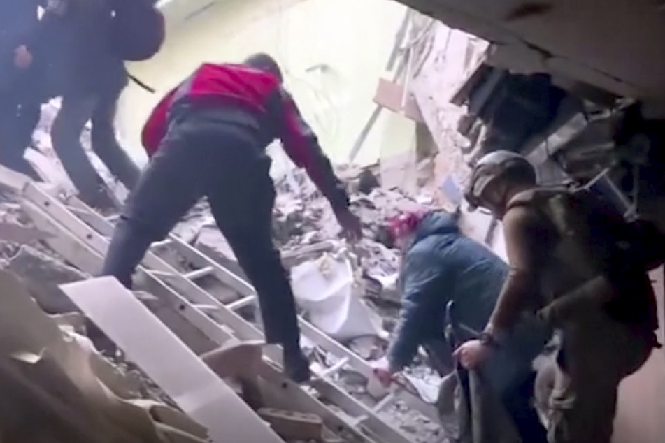 Dieses Bild aus einem undatierten Video, das 1. Mai 2022 von der ukrainischen Nationalgarde zur Verfügung gestellt wurde, zeigt Menschen, die über die Trümmer des Stahlwerks Azovstal in Mariupol klettern.