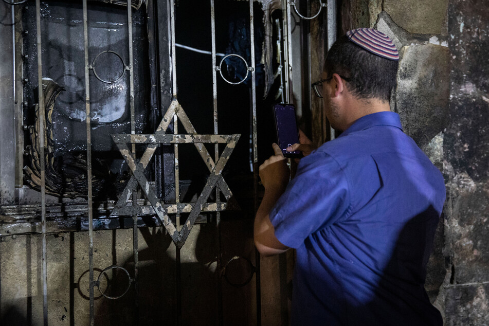 Ein israelischer Mann schaut in eine Synagoge, nachdem diese bei Zusammenstößen zwischen Juden und Arabern inmitten gewalttätiger Unruhen in der gemischt israelisch-arabischen Stadt Lod in Brand gesetzt wurde.