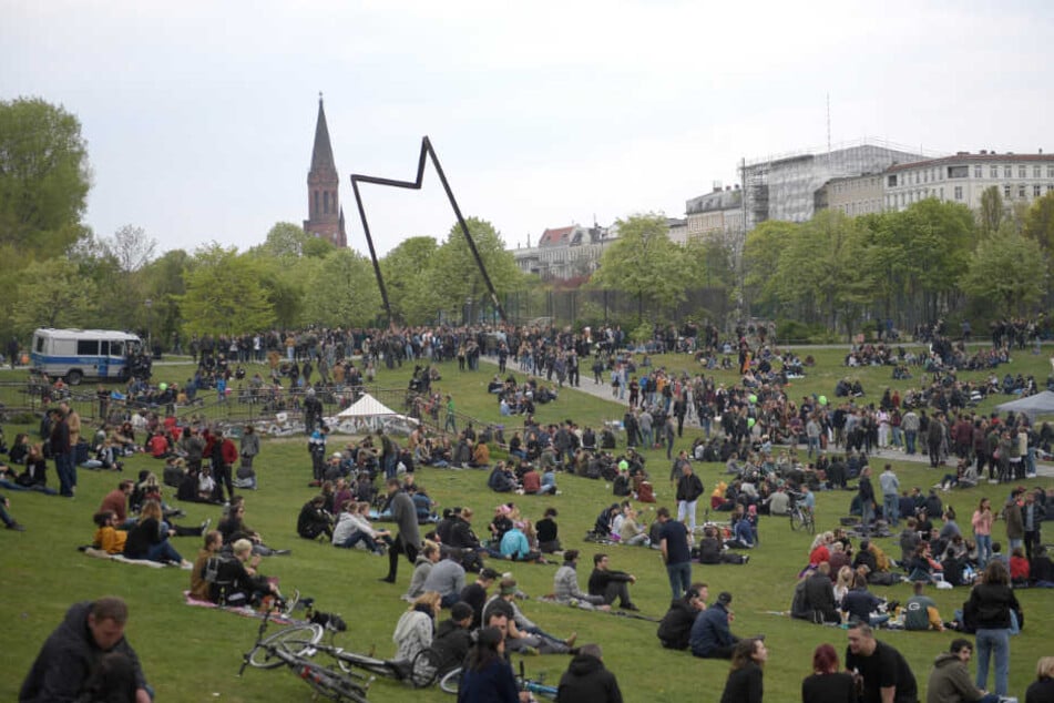 Zahlreiche Menschen sitzen im Görlitzer Park in Kreuzberg.