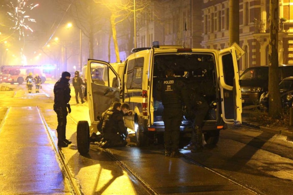 Einsatzkräfte der Polizei beim Reifenwechsel. Mehrere Fahrzeuge von Polizei und Feuerwehr waren bei dem Einsatz durch sogenannte "Krähenfüße" beschädigt worden.