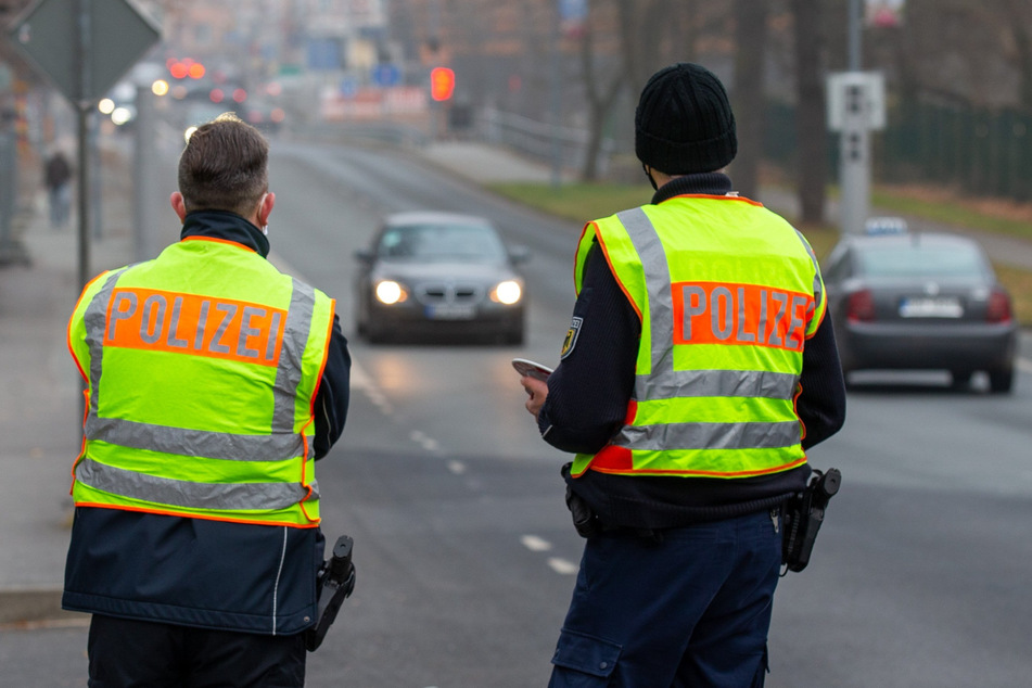 Zwei Polizisten der Bundespolizei stehen auf der Straße und beobachten den Verkehr aus Richtung Polen.