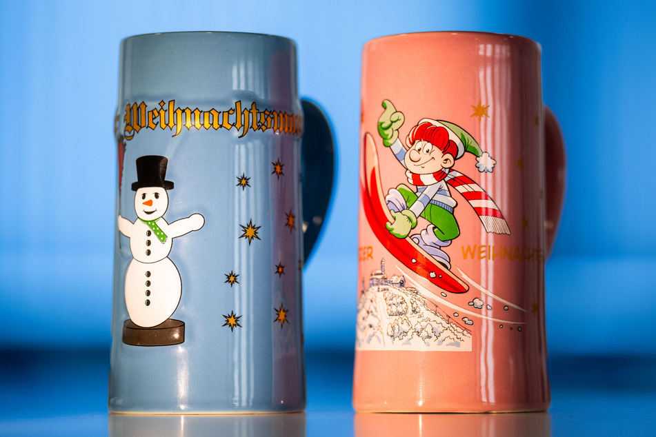 Das ist die Weihnachtsmarkttasse 2023: hellblau mit goldener Schrift und Schneemann. Auch in diesem Jahr gibt es auch wieder ein Kindergeschirr mit Abrafaxe-Motiv.