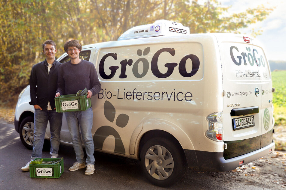 Die beiden jungen Geschäftsführer von GröGo vor ihrem E-Auto als Auslieferungsfahrzeug.