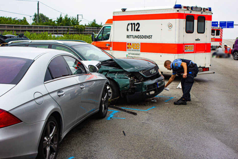 Ein Polizist markiert nach dem Unfall den Standort der Wagen.