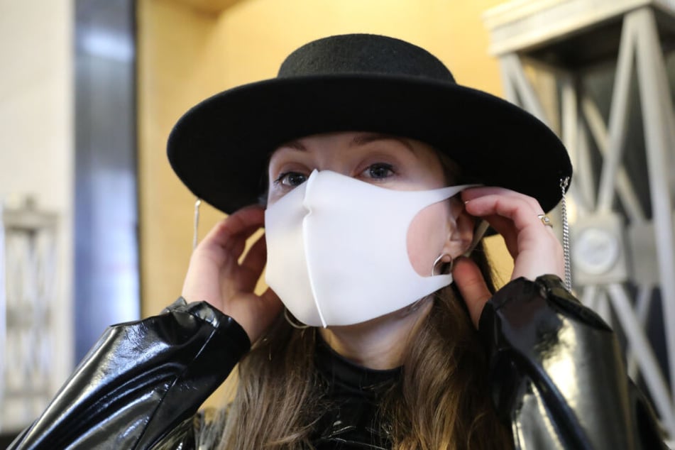 Eine Besucherin trägt eine Gesichtsmaske der Modemarke kARTu.