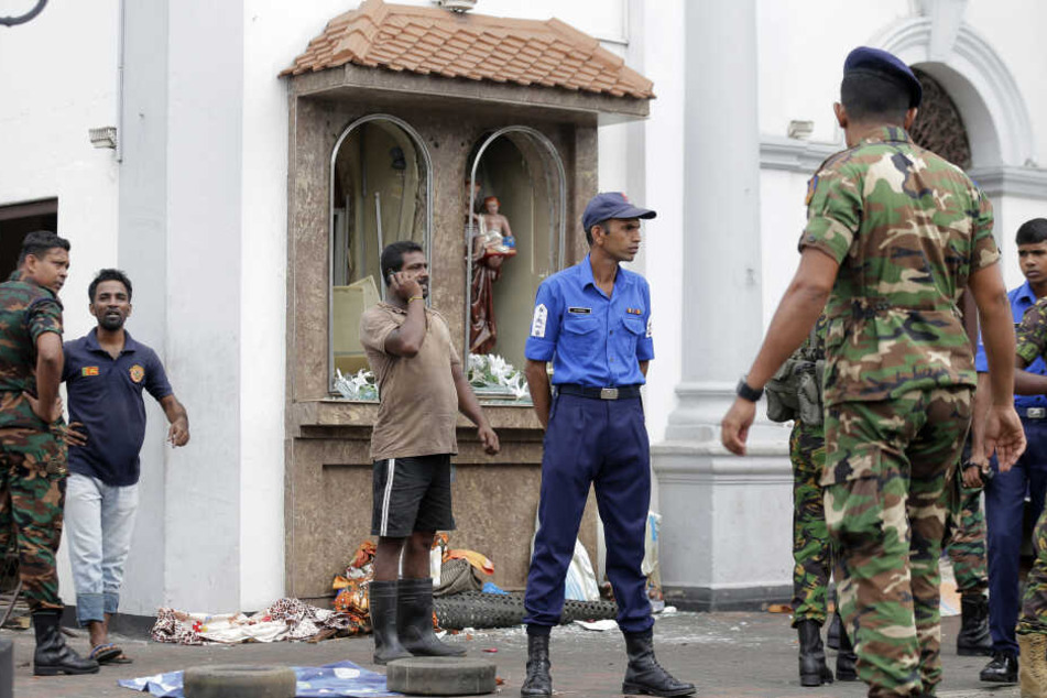 Einsatzkräfte stehen nach einer Explosion vor dem St. Anthony's Shrine in Colombo.