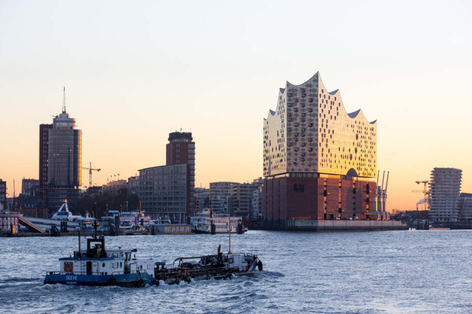 Die Elbphilharmonie leuchtet in der aufgehenden Sonne.