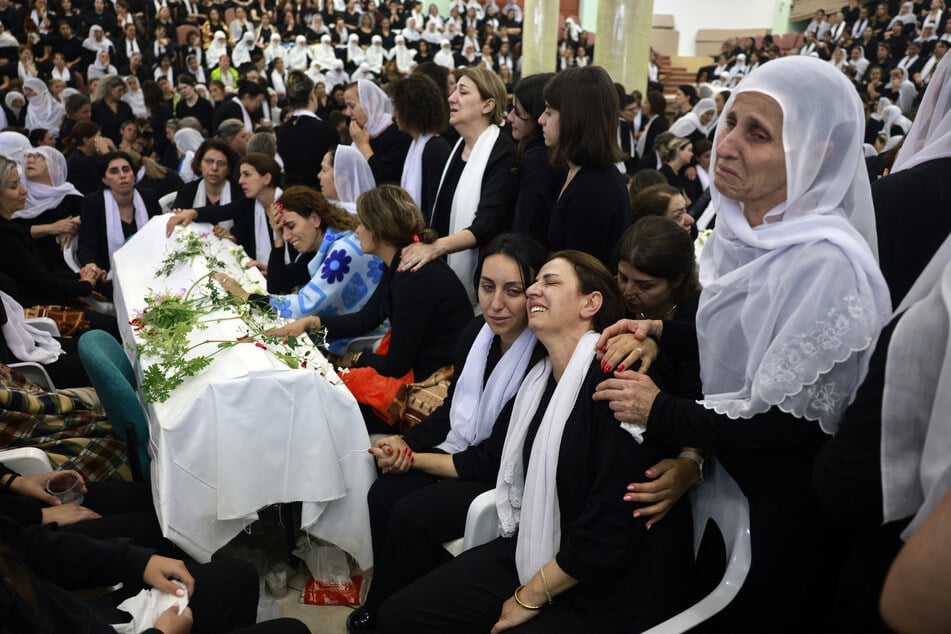 Druze women mourn by a coffin during a funeral of a person killed in a rocket strike from Lebanon a day earlier, that Israeli authorities said killed 12 people including children in the Druze town of Majdal Shams in the Israel-annexed Golan Heights, on July 28, 2024.